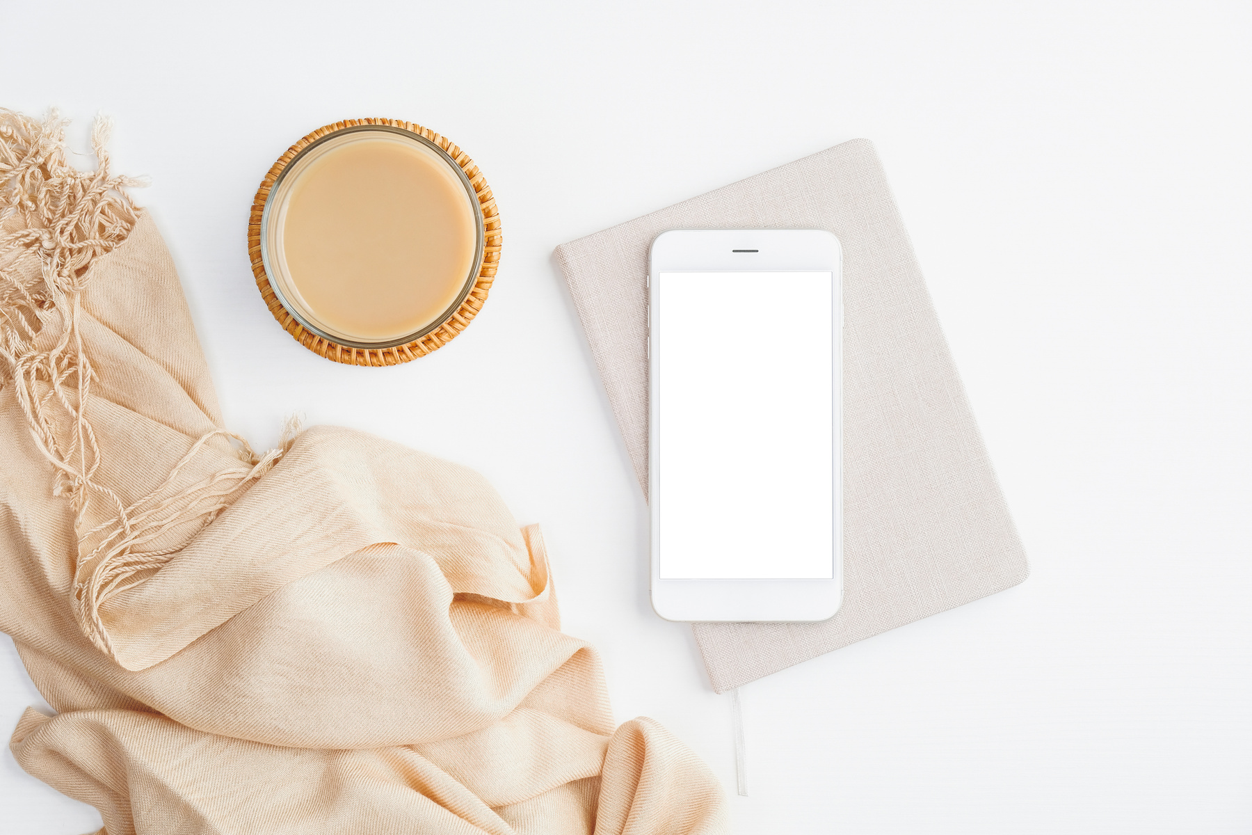 Mobile Phone on Top of a Notebook Beside a Coffee